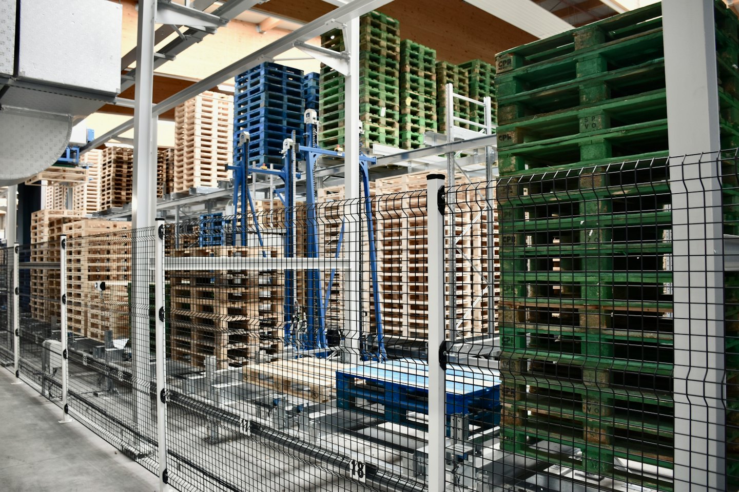 Rows of colorful wooden pallets in a modern warehouse.