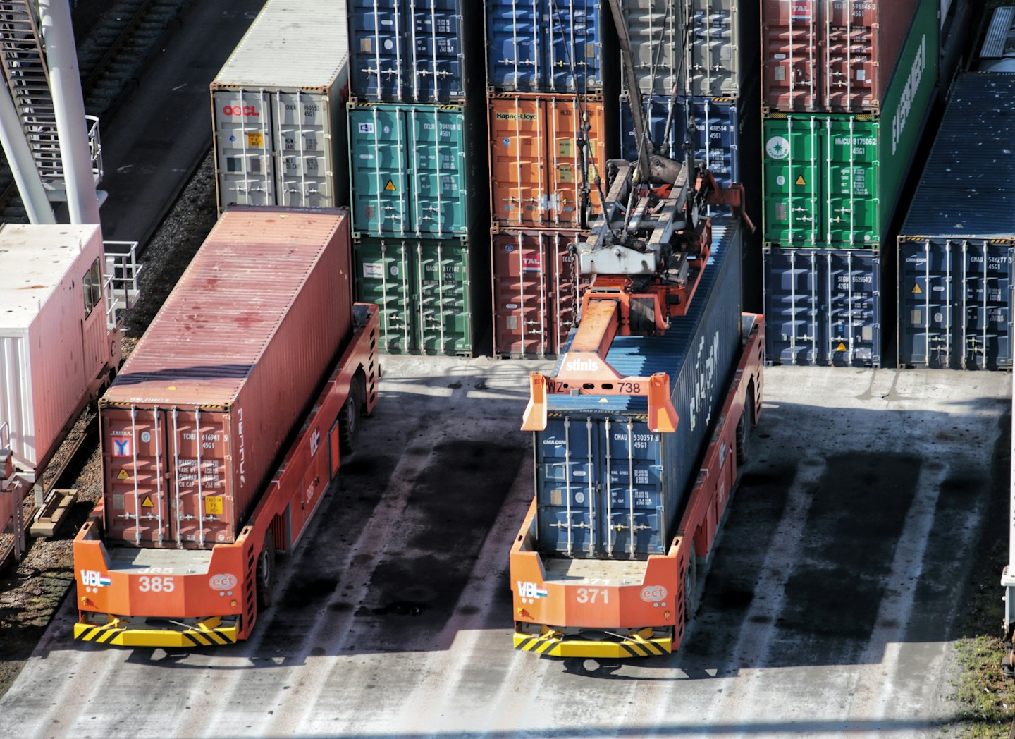 Self-propelled modular transporters move shipping containers at a terminal.